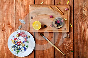 Art conceptual photo with flowers, brush, fruit spices on a pla