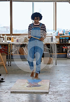 Art, creative and a woman painting on floor in studio or design school with creativity and paint brush. Artist student
