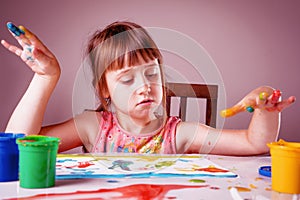 Art, creativity, holiday and childhood concept. Young beauutiful girl painting with colorful painted hands