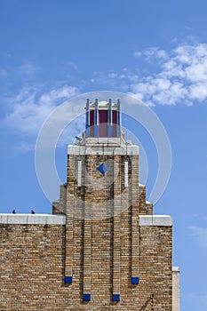 Art Deco building with birds perched on roof under pretty blue sky