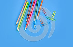 Art and drawing concepts, Colored crayon pencils and clips on blue background