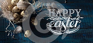 Art Easter banner with eggs and feathers in silver basket  on dark blue background. Top view, flat lay with copy space