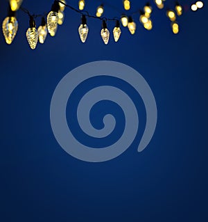 Art holiday illumination - christmas garland bokeh lights over blue background