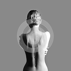 Art Nude fashion Nude back of blonde woman on grey background. G