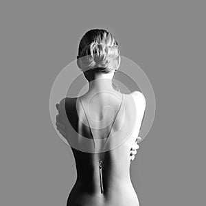 Art Nude fashion Nude back of blonde woman on grey background. G photo