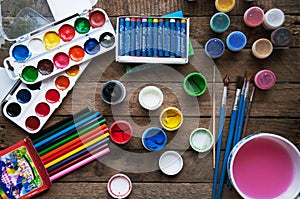Art of Painting. Paint buckets on wood background. Different paint colors painting on wooden background. Painting set: brushes, pa photo
