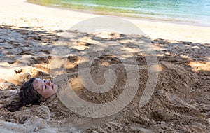 Art photo of beautiful lady buried in the sand