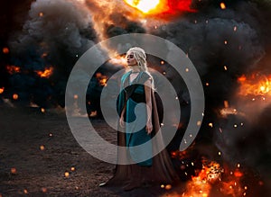 Art photo. Fantasy woman queen, blonde hair in braids. Warrior princess girl stands on background of black smoke