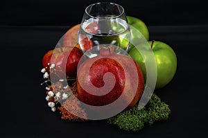 Art photo glass of water red and green apples moss of different colors on a black background 2