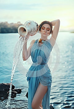 Art photo. Portrait mythical girl Greek goddess. Astrological sign Aquarius. Fantasy woman pours water from ceramic clay