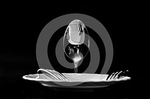 Art photo of spoons and forks with a plate in the form of a man on a black background