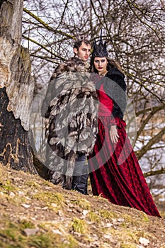 Art Photography Project. Caucasian Couple as Prince and Princess Posing in Medieval Fur Clothing in Spring Forest Outdoors