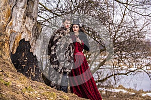 Art Photography Project. Caucasian Couple as Prince and Princess Posing in Medieval Fur Clothing in Spring Forest Outdoors