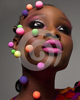 Art portrait african woman with closed eyes and creative make up in studio. Dark-skinned model with bright make-up with bright
