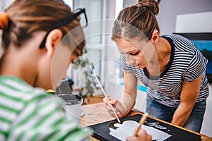 Art teacher helping a student with painting