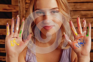 Art therapie concept. Beautiful young woman with colorful painted hands. Horizontal image