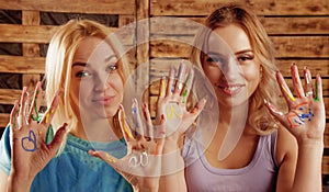 Art therapie concept. Portrait of beautiful young women with colorful painted hands