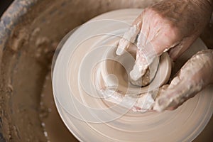 Women`s hands and potter`s wheel