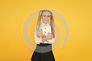 Art training. Happy girl holding school scissors on yellow background. Small girl preparing for arts and crafts classes
