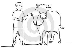 A boy holding a sacrificial cow