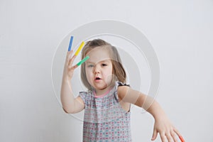 Artful child playing with felt tip pens. baby girl painting and playing. colorful stuff felt pen caps on fingers