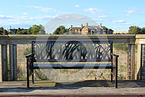 Artful metal garden bench on a boardwalk