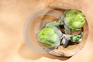 Artichoke close up. Fresh raw organic green Artichokes closeup. Over beige background. Healthy vegetarian food