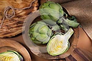 Artichoke close up. Fresh raw organic green Artichokes closeup. Over wooden table. Healthy vegetarian food.