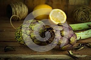 Artichokes posed and lemon on background with strings