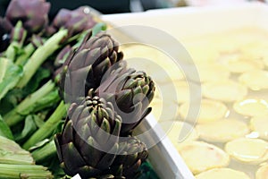 Artichokes for sale in stand of greengrocers to local market photo