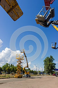 Articulated boom lift, scissor lift, other lifts buckets on foreground