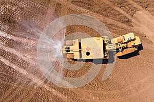 Articulated Water Truck spraying water, Aerial image.