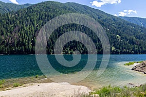 Artificial alpine reservoir lake Zoccolo Zoggler-Stausee and mountain range at Ultental, South Tyrol