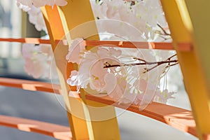 Artificial blooming apple tree in orange wooden fence