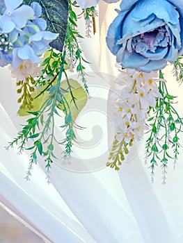 Artificial blue and white flowers decorate the arch as the backdrop in the wedding ceremony. Flowers background.