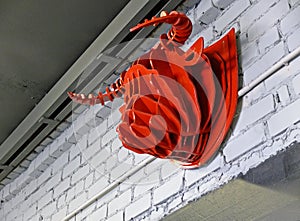 Artificial bull`s head hanging on a white brick wall