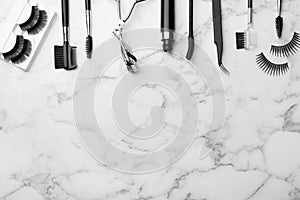 Artificial eyelashes and accessories on marble background