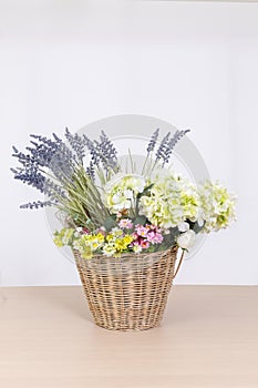 Artificial flower bouquet in basket on white background.