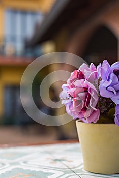 Artificial flower in pot on the table. Selective Focus.