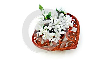 Artificial flower and red heart on white background, wedding interior detail close up