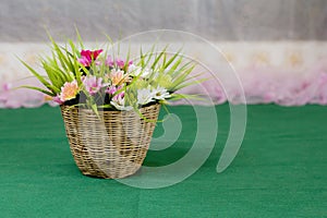 Artificial flower in wooden basket.