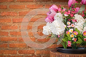 Artificial flowers and brick wall.