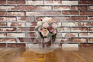 Artificial flowers put on terrace wood with brick wall in vintage style