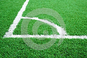 Artificial grass of football field with white stripe, Soccer corner line detail, Green astro turf for texture background