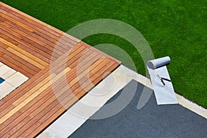 Artificial grass installation in deck garden with tools