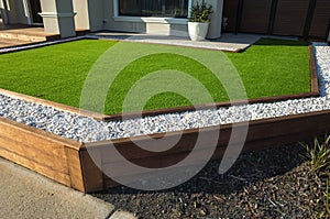 Artificial grass lawn turf with wooden edging in the front yard of a modern Australian home.