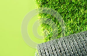 Artificial grass roll on a green background