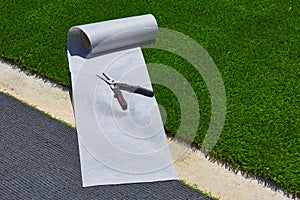 Artificial grass turf installation in garden with tools