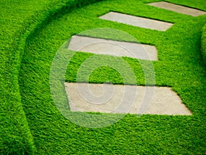 Artificial green grass walk way with concrete plate