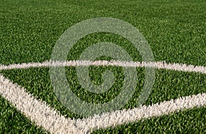 Artificial green grass and white border lines. Artificial turf for soccer field. Football field in an outdoor stadium